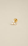 Angled still life photo of 14K solid gold Trinity Knot flat back labret stud, three pear shape cz ear piercing jewelry on soft beige background