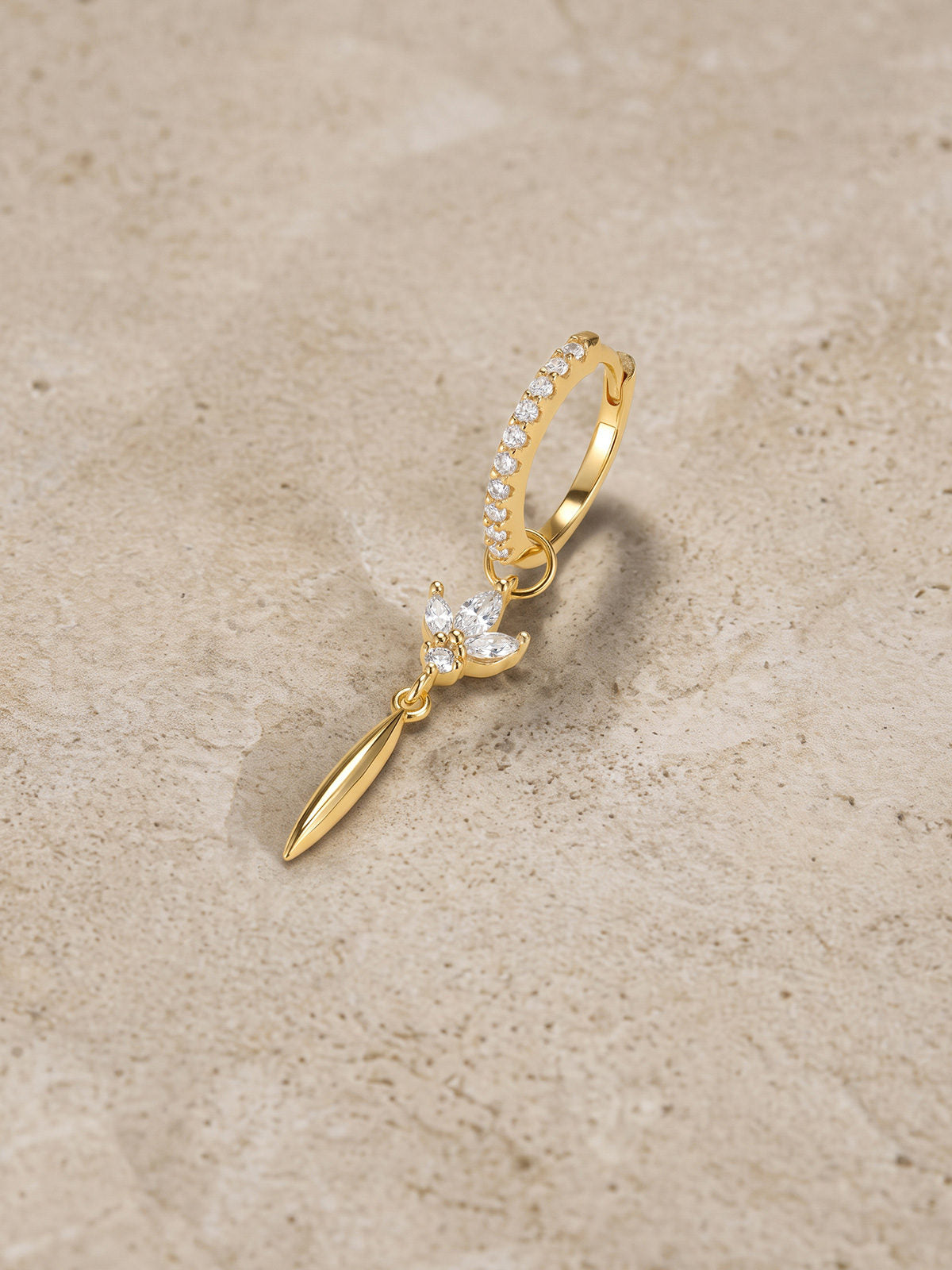 Side view of 18K gold plated hoop with lotus crystal charm and tassel drop