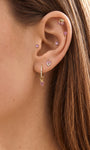 Soft feminine ear stack featuring KOSINER Pink Ritual key piercing stud on helix area, coordinated with heart hoop pendant, cherry and tiny round gem studs, natural close-up of versatile ear matching design