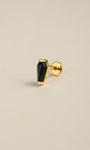 Angled still life photo of 14K solid gold black coffin flat back labret stud, black onyx goth ear piercing jewelry on soft beige background