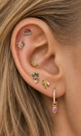 Mixed ear stack look of KOSINER Orchard fruit & ocean jewelry lines, watermelon cartilage stud paired with grape, seashell, palm tree studs and strawberry dangle hoop