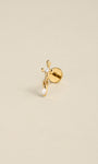 Angled still life shot of 14K solid gold broken sword drop flat back labret stud, clear CZ dangle piercing jewelry on soft beige background