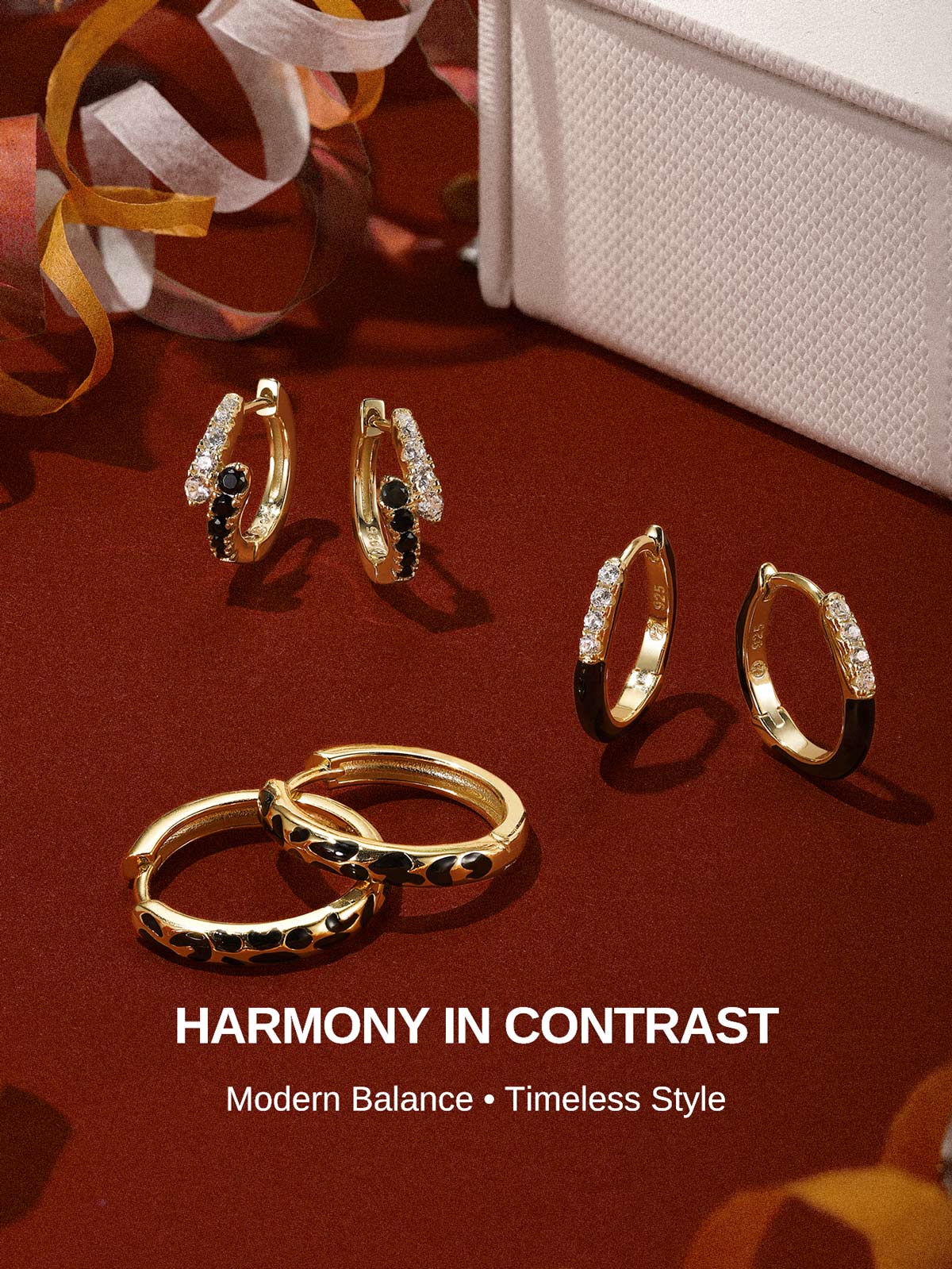 KOSINER Puzzle collection hoop earrings arranged on burgundy backdrop, featuring two-tone cz black enamel hoops, leopard print hoops, two-tone stone-set huggie pairs, slogan Harmony In Contrast, modern contrast design fashion earring lineup