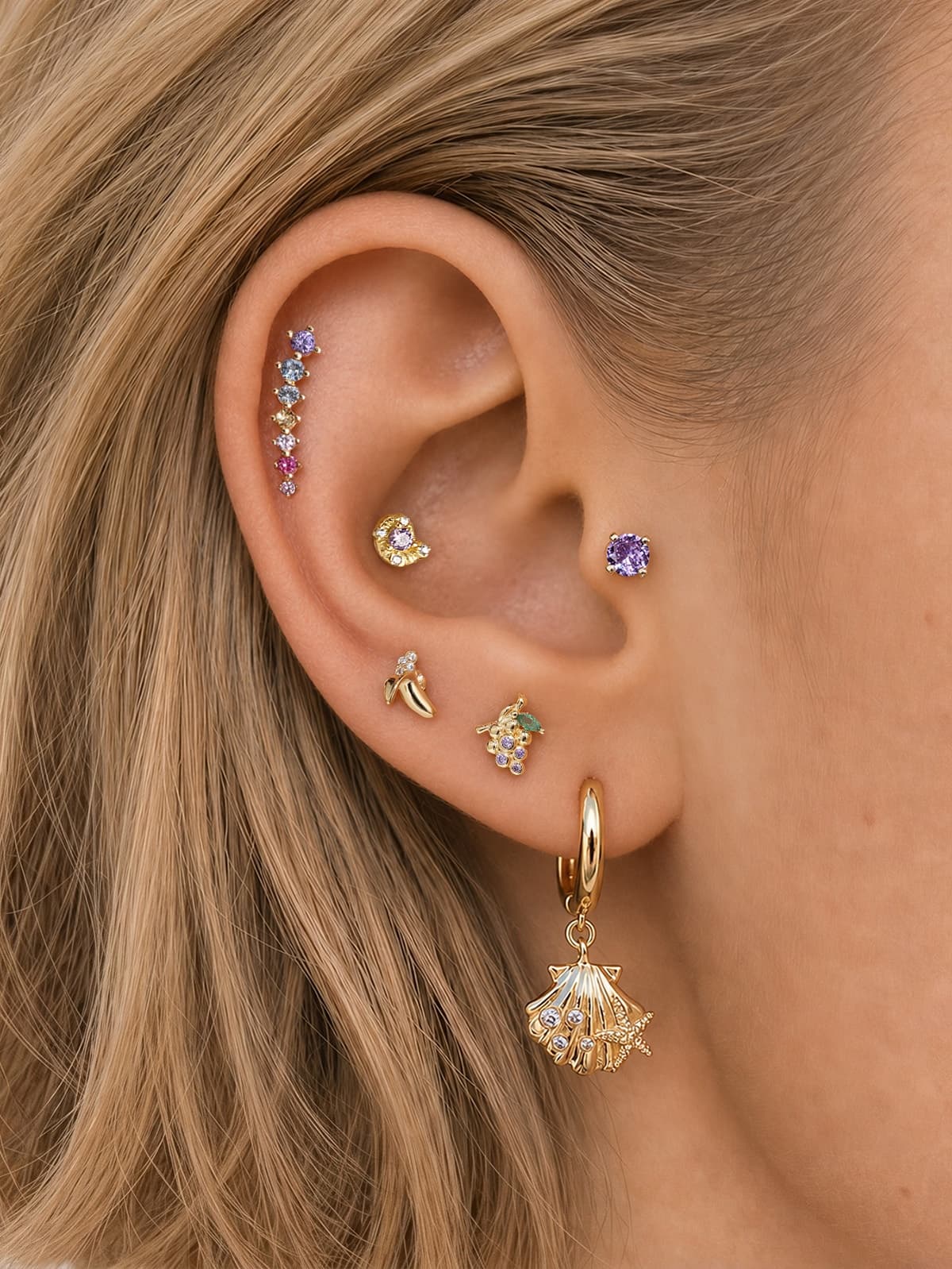 Mixed stack look of KOSINER Orchard fruit & sea series, banana cartilage stud paired with gradient rainbow stone, seashell dangle hoop, purple solitaire piercing studs