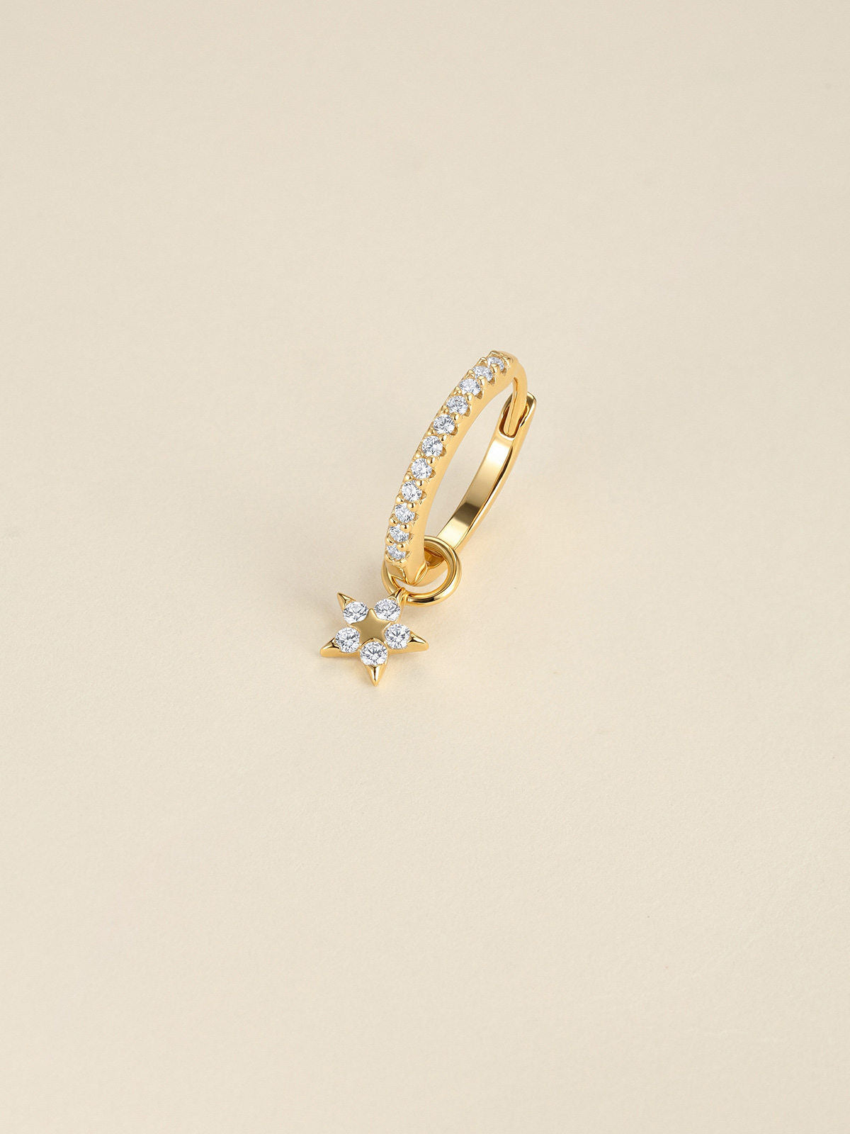 KOSINER Rising Star gold-plated star dangle hoop worn in the first lobe piercing with matching celestial studs