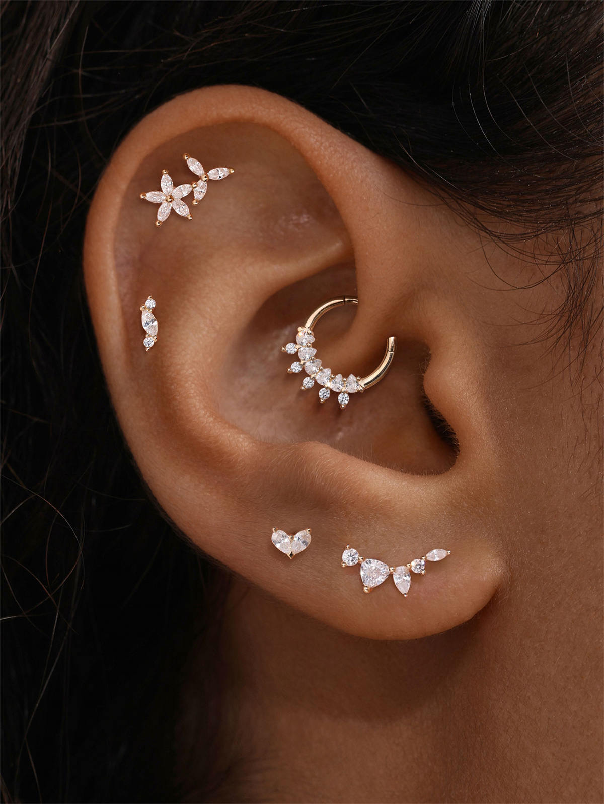 KOSINER ear stacking look with assorted KOSINER 14K solid gold heart-shaped cartilage piercing studs, multi-position helix lobe layered ear jewelry styling