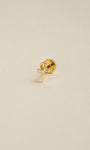 Angled still photograph of 14K solid gold Ankh cross flat back labret stud, Egyptian Ankh symbol earring on soft beige background