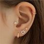 Rose gold 925 sterling silver flower stud with cubic zirconia and flat back closure on ear.