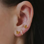 Gold 3-piece earring set: two butterfly studs and one small cubic zirconia hoop on ear.