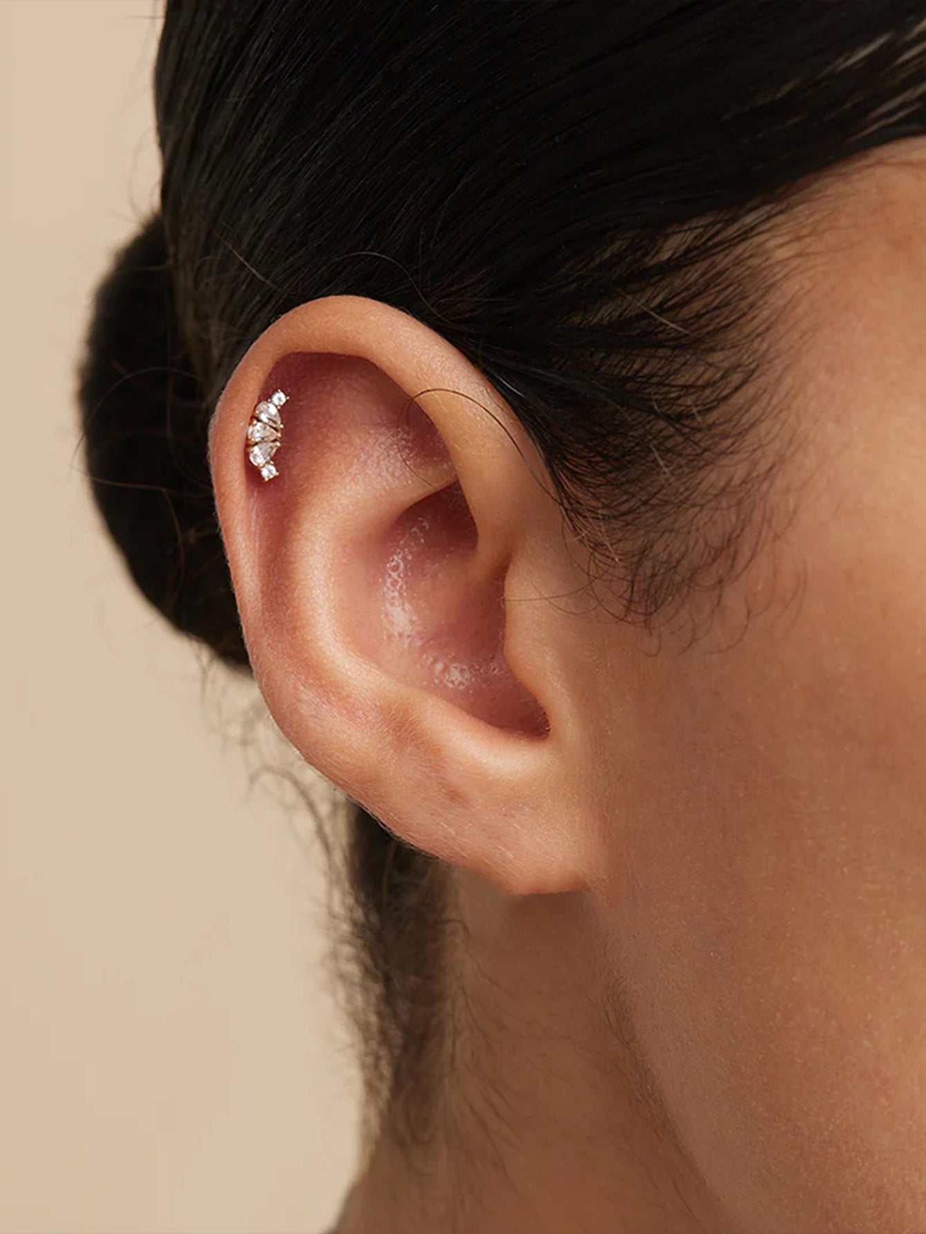 Gold 925 sterling silver cartilage earring with sparkling cubic zirconia stones on ear.