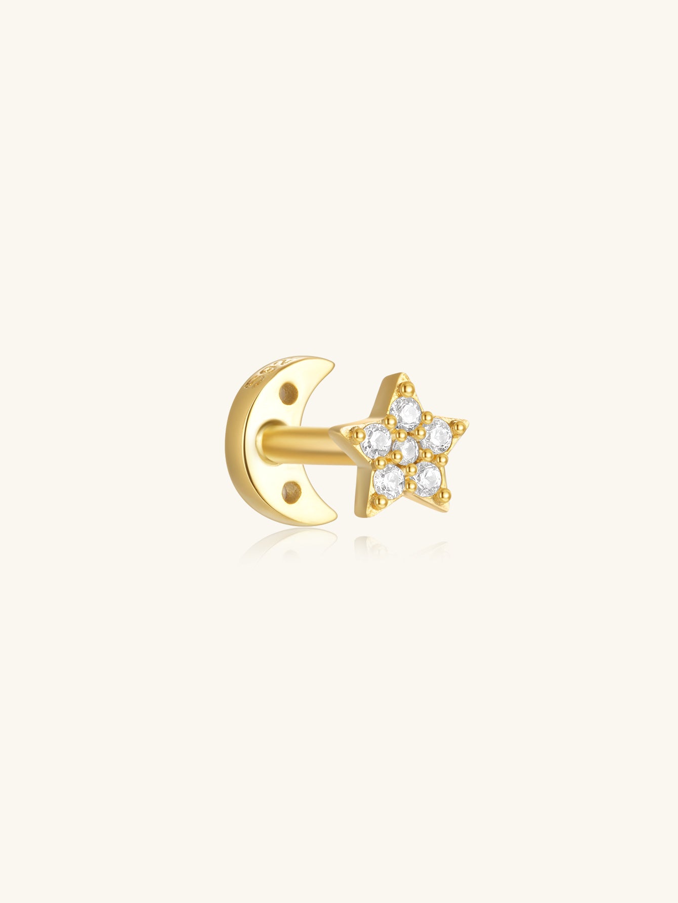 Gold plated sterling silver piercing earring with reversible star and moon design, adorned with zircons.