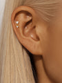 Gold plated 925 sterling silver flat back labret stud with two dangling heart cubic zirconia stones on ear.