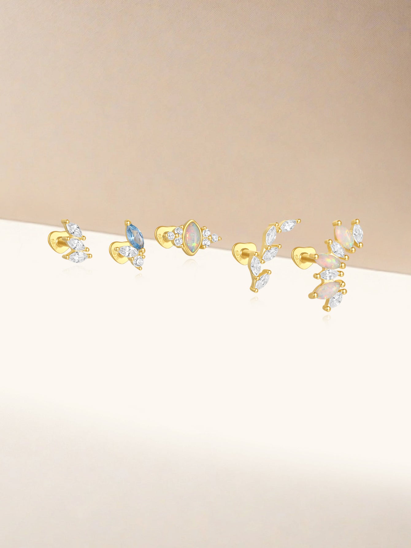 Collection of 18kt gold-plated sterling silver stud earrings, featuring leaf and marquise shapes with cubic zirconia stones.