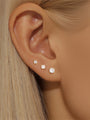 Three 18kt gold plated sterling silver round CZ studs (2mm, 3mm, 4mm) on earlobe for size reference.