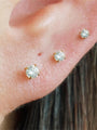 Three 18kt gold plated sterling silver round CZ stud earrings (2mm, 3mm, 4mm) displayed on earlobe for size reference.