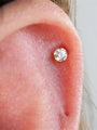 4mm 18kt gold-plated sterling silver round cubic zirconia stud earring with flat back labret, shown on earlobe.