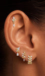 Close-up of KOSINER olive branch marquise drop stud styled in a botanical ear stack