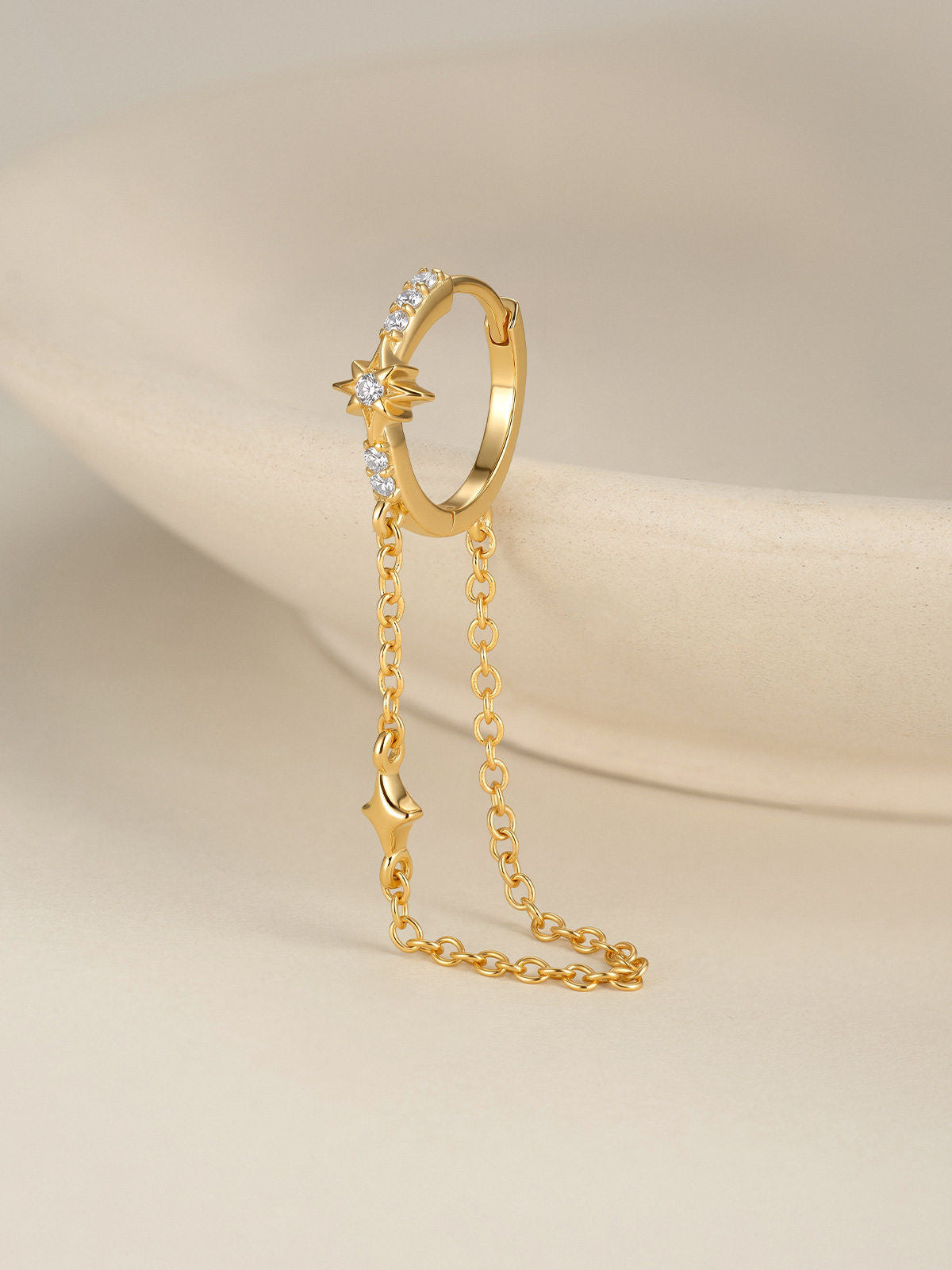 KOSINER Rising Star gold-plated star chain hoop worn in the first lobe piercing with celestial studs and an ear cuff