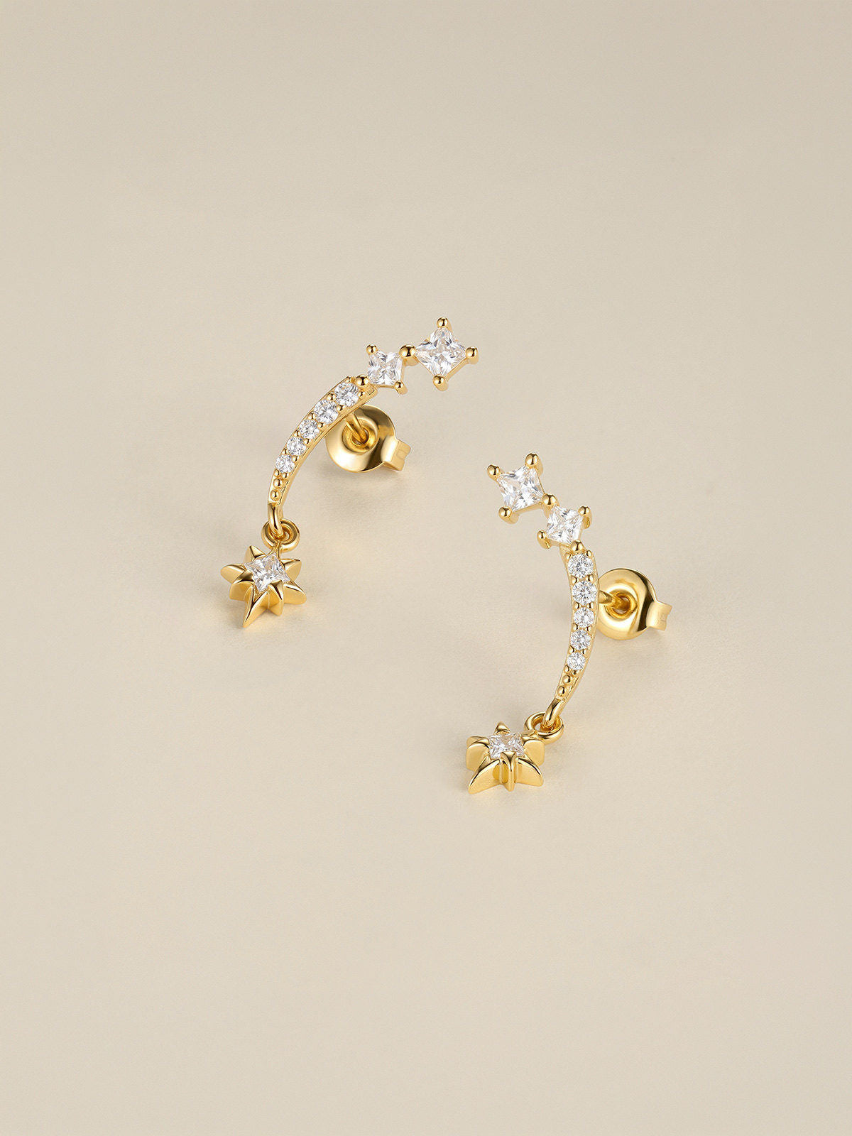 Pair of KOSINER Rising Star gold-plated earrings with mirrored curved bars, clear stones and dangling stars