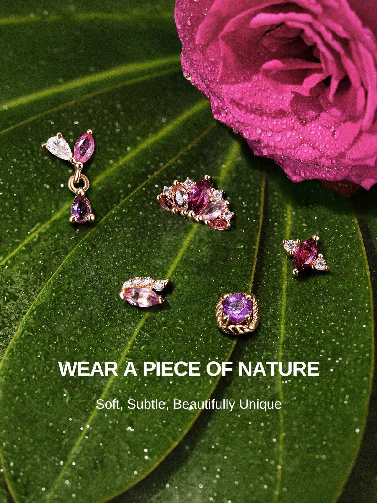 KOSINER Gem Garden nature-inspired purple gem piercing studs laid on dewy green foliage and magenta rose, featuring twist amethyst, crown cluster, pear dangle, three-stone multi-shape flat back designs