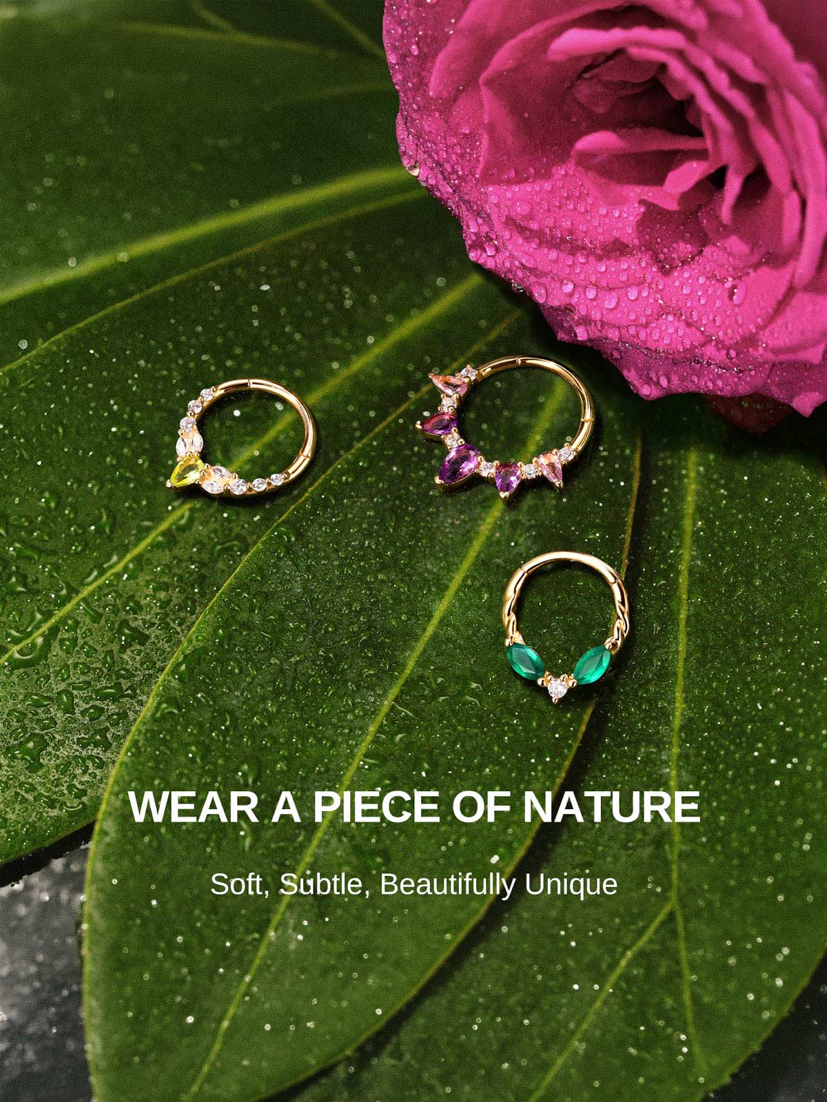 KOSINER Gem Garden nature-inspired gem clicker hoops displayed on dewy green leaves and magenta rose, featuring gradient pear amethyst, peridot, emerald two-stone twisted hoop styles