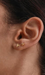 Extreme close-up shot of earlobe styled with KOSINER 14K gold mermaid tail flat back stud paired with mini seastar piercing stud, delicate minimalist daily two-piece ear stacking design