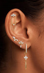 Model wearing KOSINER gold lotus tassel drop hoop in a curated ear stack