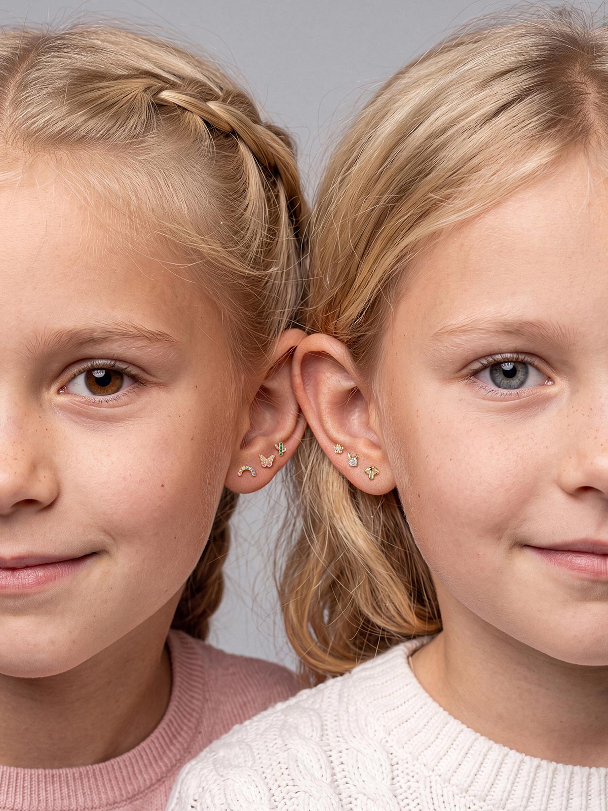 Two models wearing Little Wonder 14K gold flat back studs in curated ear stacks