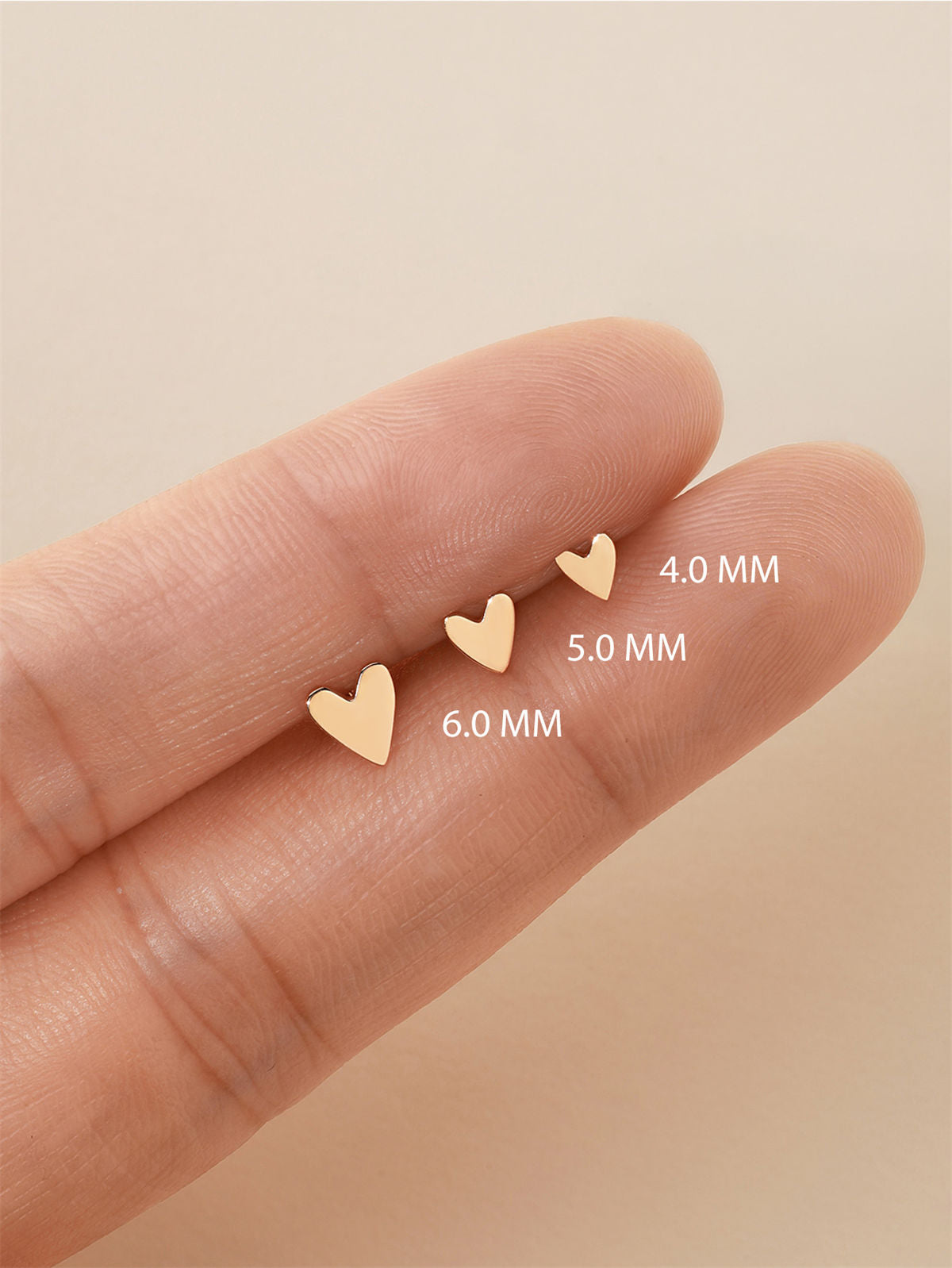 KOSINER 14K solid gold heart stud worn solo or layered in curated ear stack