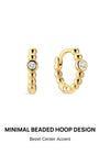 KOSINER Perléa Minimalist Beaded Hoop earring pair front view, rounded huggie hoop constructed from smooth polished spherical beads, single bezel-set round clear cubic zirconia center stone, gold-plated finish over premium 925 sterling silver base with hinged snap closure