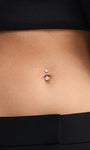 Full midsection lifestyle photo with model wearing black crop top and tailored trousers, subtle understated styling of tiny sized KOSINER 14K solid gold classic navel piercing stud