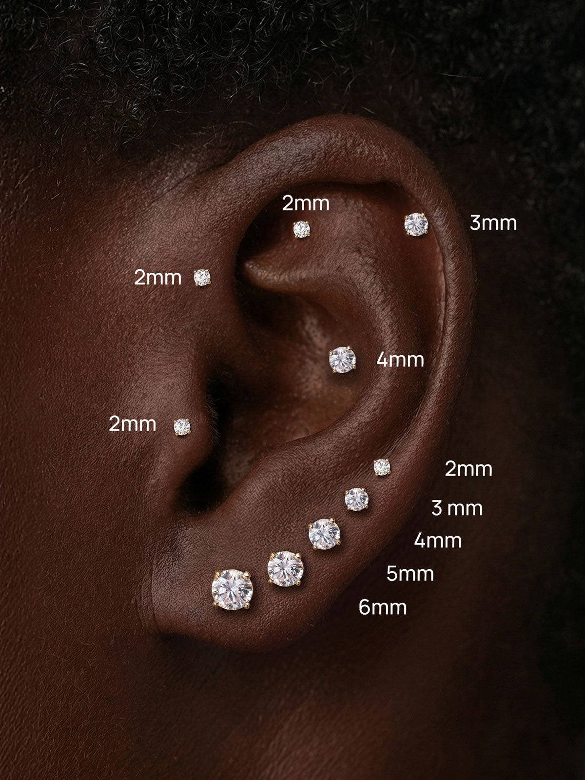 Curated full ear styling showcasing KOSINER round lab-grown diamond flat back studs ranging 2mm–6mm, placed across tragus, helix and earlobe piercings for visual size comparison