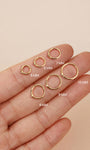 KOSINER diamond clicker hoops ranging 5mm through 10mm laid across fingertip with printed size markings to visualize diameter differences