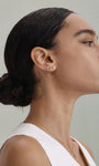 Elegant daily look with KOSINER Seaspritz wine glass flat back stud on earlobe, model with sleek low bun and plain white tank top, soft neutral background showing the refined wearable design of holiday piercing jewelry