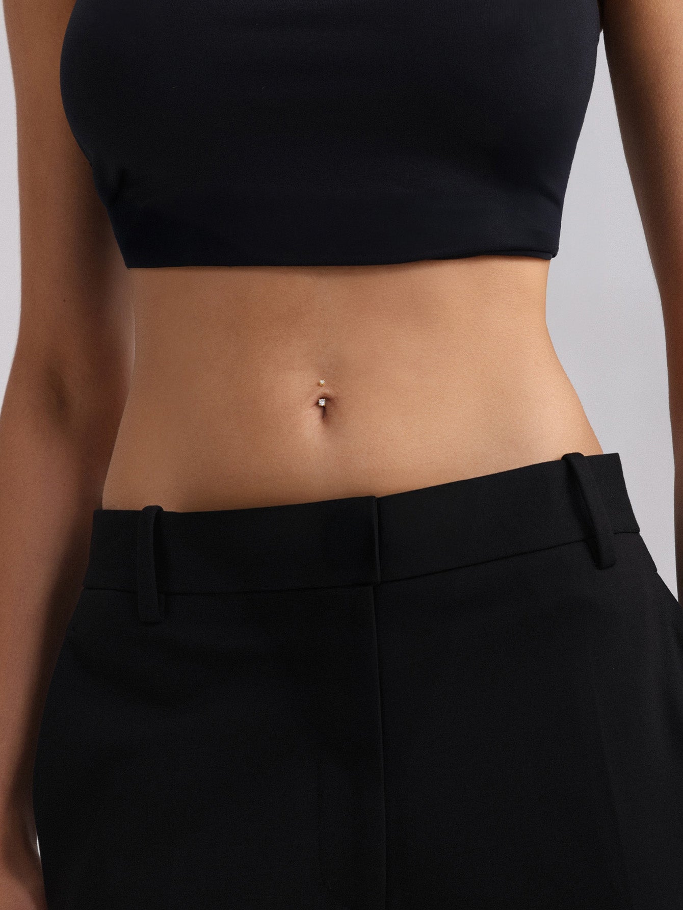 Exploded view of internally threaded KOSINER 14K solid gold navel stud, separated curved banana bar post and threaded screw end topped with prong-set clear CZ, showing secure internal thread structure for body piercing safety