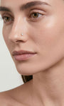 Soft natural portrait of a woman wearing tiny KOSINER L-shaped nose stud, delicate subtle nostril piercing for casual elegant facial jewelry styling
