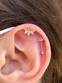 Gold plated 925 sterling silver five-lobed ear piercing stud with chain and marquise CZ stones, shown on ear.