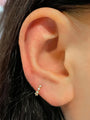 Single 6mm 18K gold plated sterling silver hoop earring with 3 clear cubic zirconia stones on ear lobe.