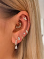 Gold-plated 925 sterling silver trio round zircon 6mm hoop earring on ear, styled with other cubic zirconia earrings.