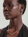 Model wearing 14K solid gold square stud and bee stud earrings with clear cubic zirconia stones.