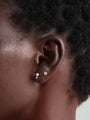 14K solid gold classic round ear piercing stud with sparkling cubic zirconia on ear.