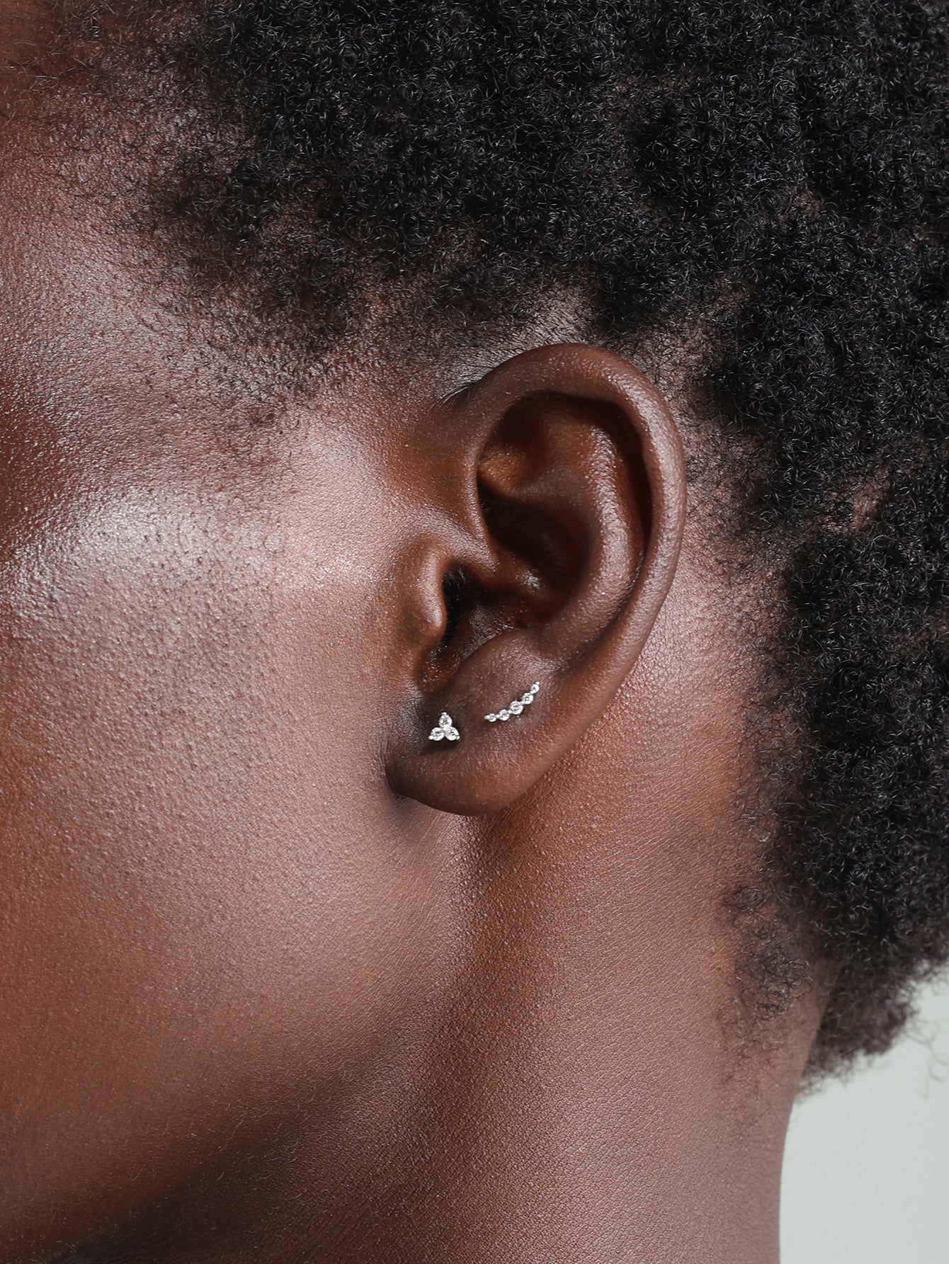 14K gold trinity stud piercing with cubic zirconia, and curved bar piercing on ear.