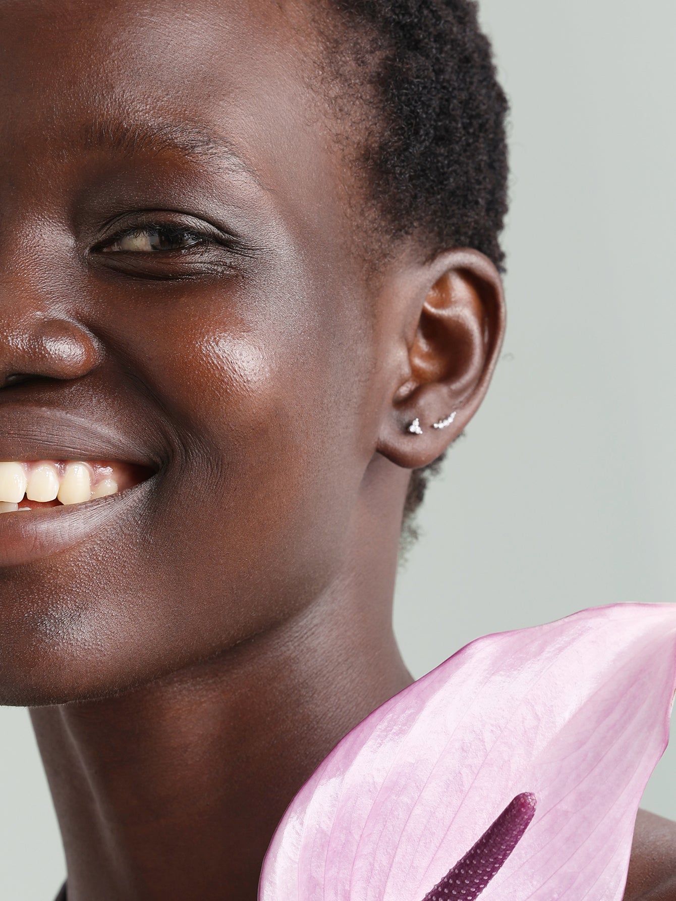 14K solid gold trinity stud piercing with ultra shine cubic zirconia, showcased on an ear.