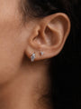 14K solid gold trinity ear piercing studs with cubic zirconia stones, shown on ear.