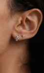14K solid gold trinity ear piercing studs with cubic zirconia stones, shown on ear.