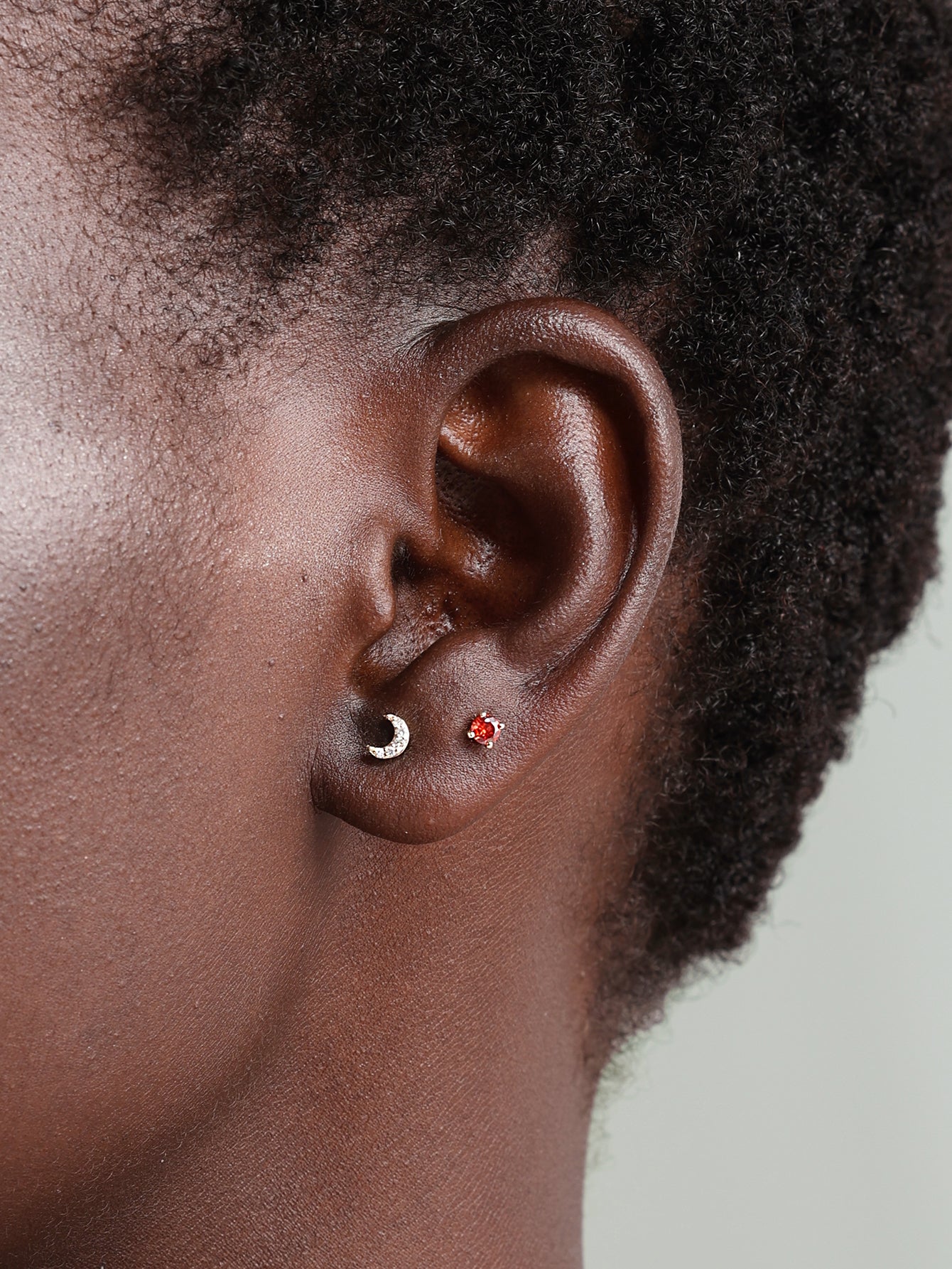 14K gold moon stud piercing with diamonds on earlobe, shown with flat back closure.