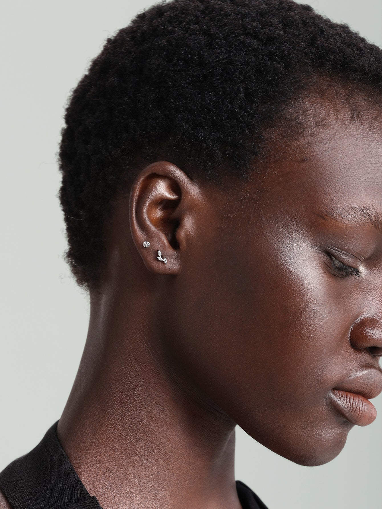 14K gold leaf stud earring with cubic zirconia on ear, internally threaded flatback.