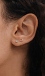 14K solid gold labret studs with cubic zirconia: round stud and mini moon stud on earlobe.