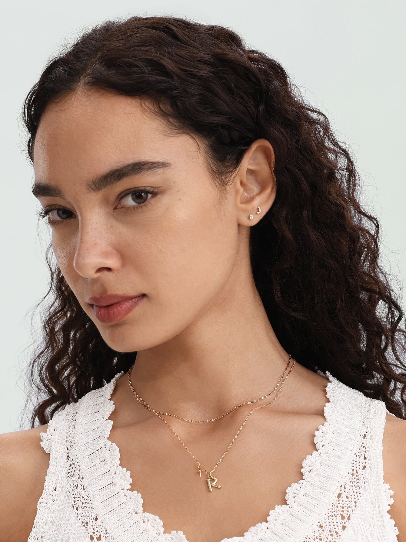 14K solid gold moon stud piercing with sparkling stones, worn on model's earlobe with flat back.