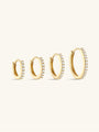 Four 14K solid gold hoop huggie earrings of various sizes, paved with clear cubic zirconia crystals.